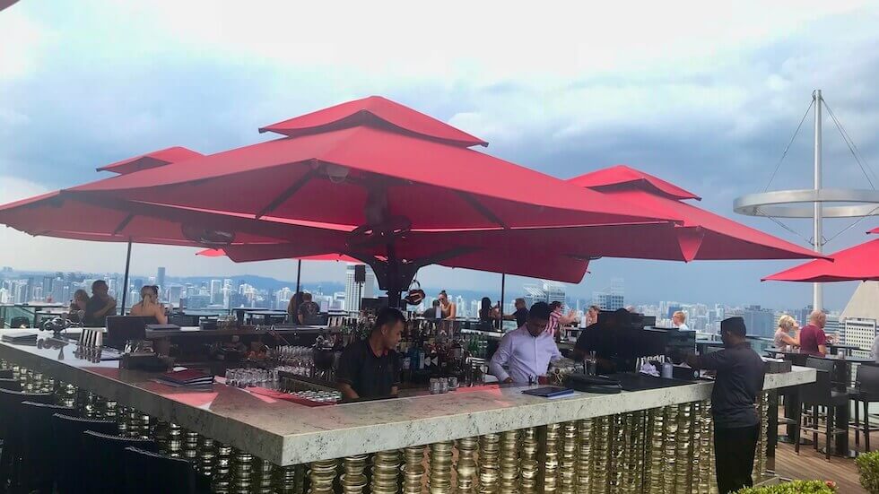 Hotellin Marina Bay Sandsin SkyBarin baaritiski, jonka ylla iso punainen aurinkovarjo Singaporessa.