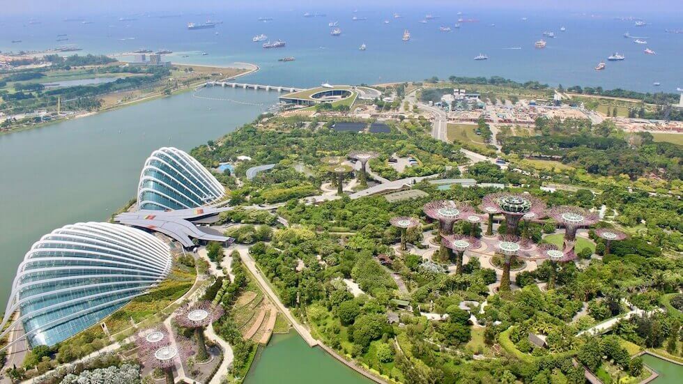 Singaporen Gardens by the Bay kuvattuna korkealta Marina Bay Sands Skybarista. Taustalla meri ja laivoja.