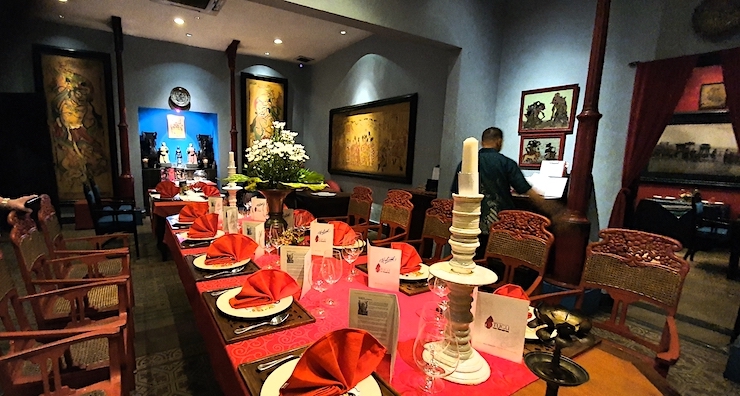 Ravintola Lara Djonggranin katettu ruokapoyta, jossa on punaiset lautasliinat ja poytaliinat.