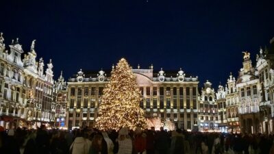 Brysselin joulumarkkinoilla olevia historiallisia rakennuksia jouluvaloissa Grand Placella ja iso valaistu kuusi.