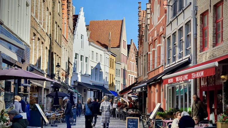 Bruggen kapealla ostoskadulla kulkee turisteja. Ostoskadulla vanhoja historiallisia rakennuksia.