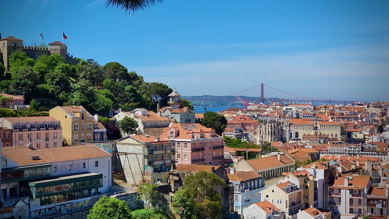 Lissabonin kaupunki ja Alfaman kukkulalla sijaitseva linna ja taustalla meri ja silta.