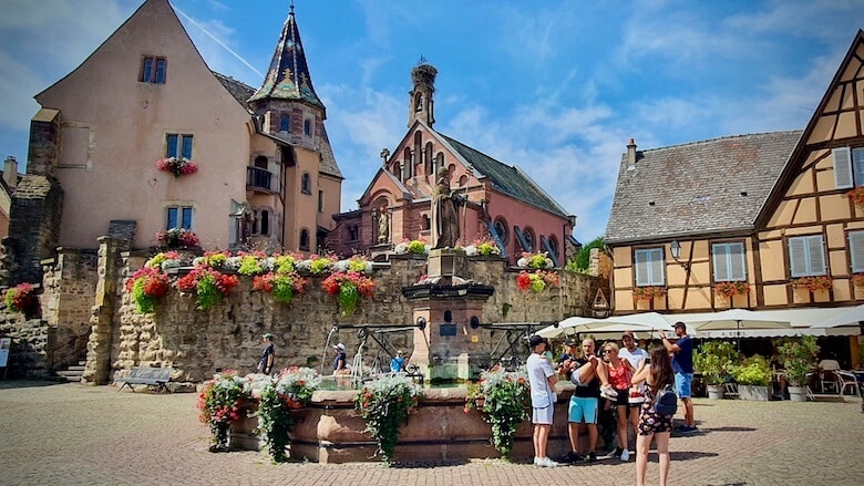 Eguisheimin keskusaukio. Aukiolla keskiaikainen linna, kappeli ja patsas.