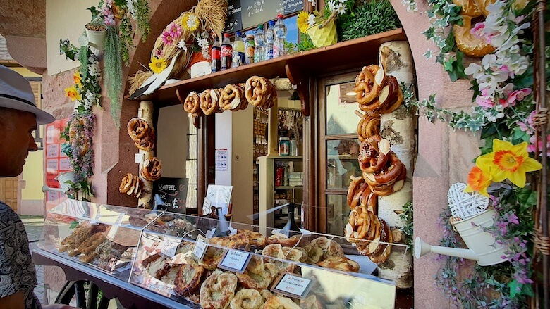 Paikallinen herkkukioski, jonka luukusta voi ostaa ja sen suuaukko on koristeltu leipomotuotteilla.